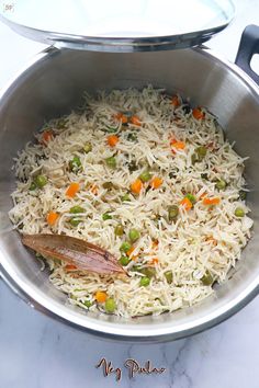 a pot filled with rice and vegetables on top of a table