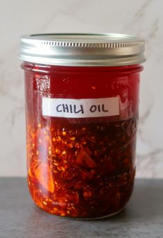 a jar filled with chili oil sitting on top of a table