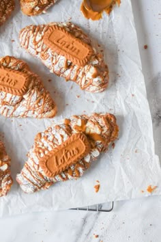 several pastries with peanut butter and powdered sugar sitting on top of parchment paper