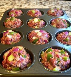 a muffin tin filled with meat and vegetables