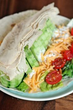 a salad with chicken, lettuce and tomatoes on it is sitting on a plate