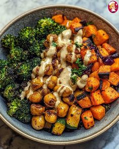 broccoli, carrots and other vegetables in a bowl with dressing on top