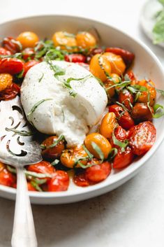 a white bowl filled with tomatoes and cheese