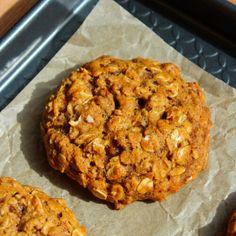 three cookies sitting on top of a piece of wax paper
