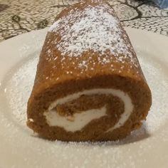 a roll covered in powdered sugar on a plate
