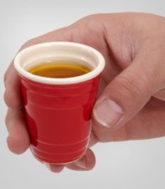 a hand holding a red cup filled with liquid