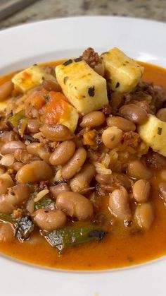 a white plate topped with beans and tofu