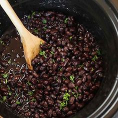 a wooden spoon stirring beans in a pot