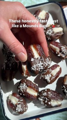 someone is picking up some chocolate covered dates