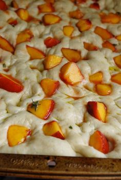 a close up of a pizza with peaches on it
