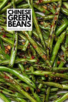 chinese green beans in a white bowl with red chili flakes on top and the words, chinese green beans