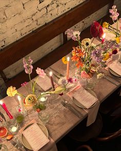 the table is set with flowers and candles