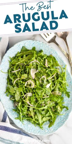 the best arugula salad is on a blue and white plate with silverware
