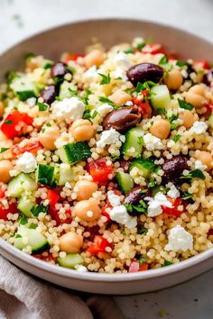 a bowl filled with couscous and vegetables on top of a white table cloth