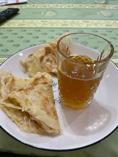 a white plate topped with quesadillas next to a cup of tea