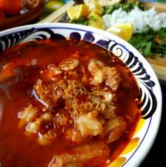 a bowl filled with food sitting on top of a table next to other plates and utensils