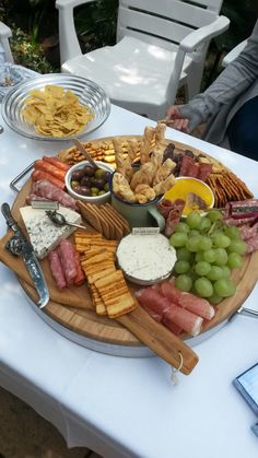 a platter of cheeses, crackers, and meats on a table