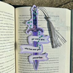 an open book with some stickers on it and a tassel hanging from the pages