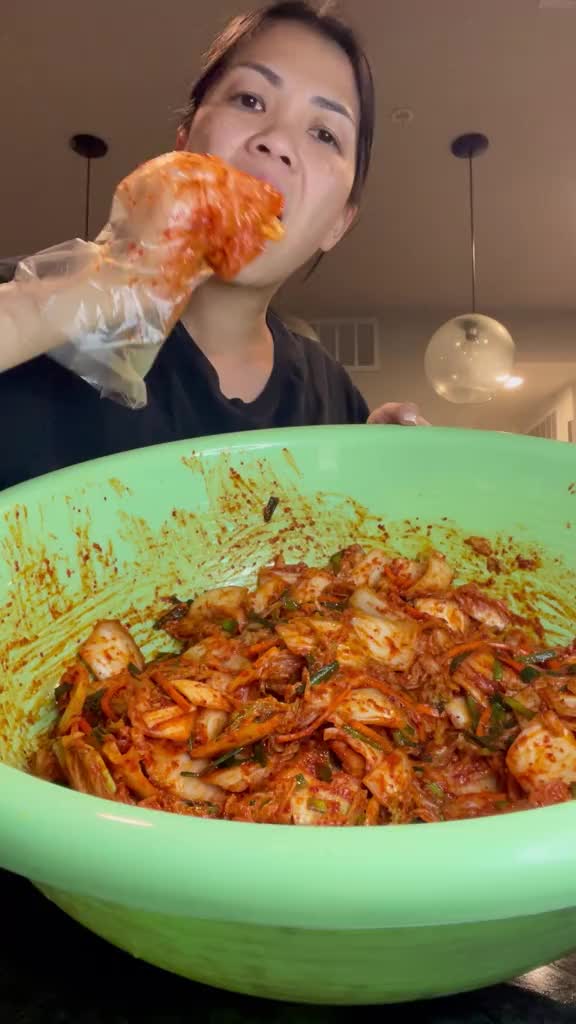 This contains: A vibrant bowl of traditional Korean kimchi, showcasing its bright red color and assorted vegetables.