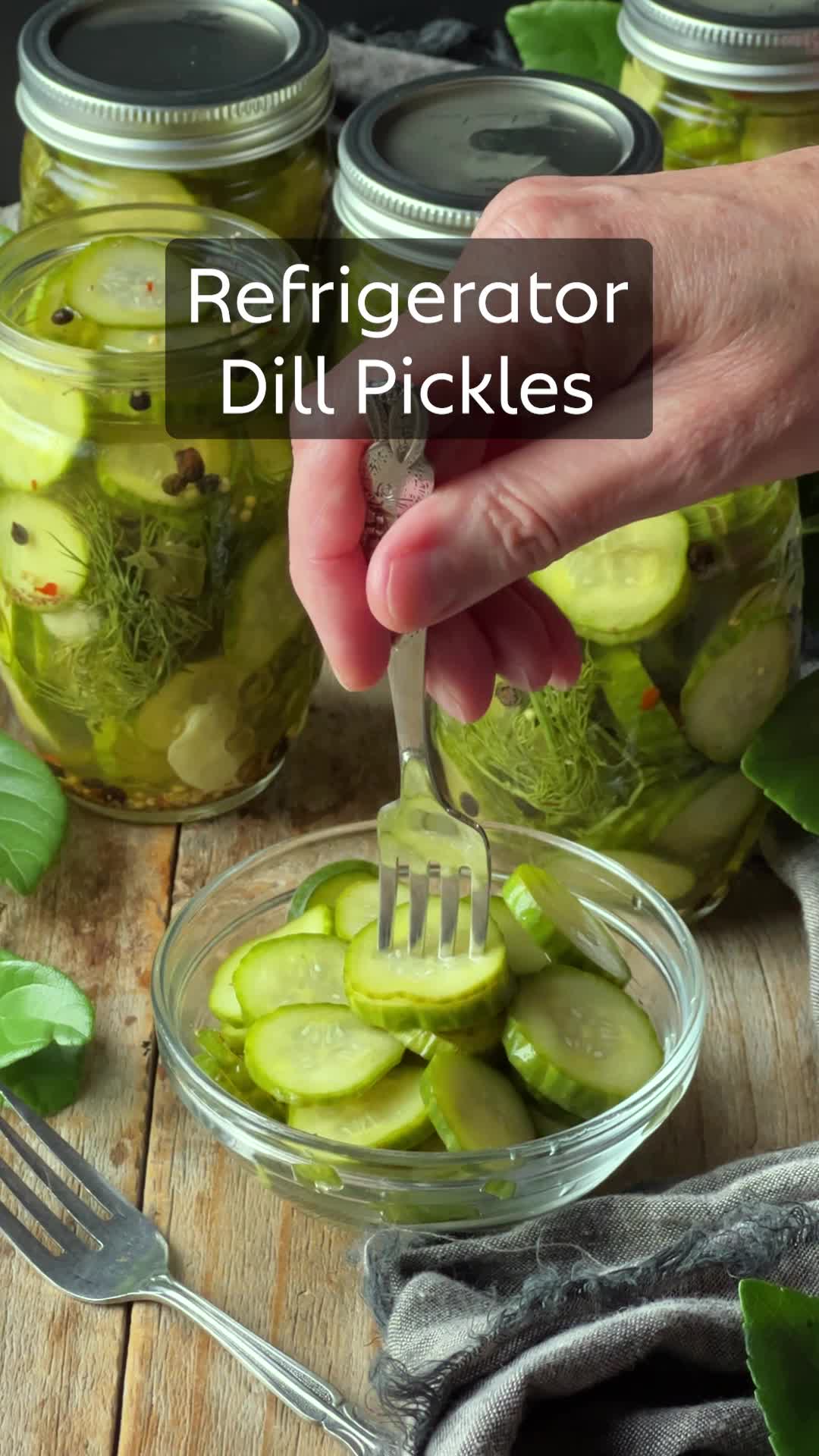 This contains: Watch how to make refrigerator dill pickles. Start by gathering the ingredients and making the brine on the stovetop.  Then, add the spices and pickles to clean canning jars and fill with the brine.  Shake to combine and refrigerate for at least 3 days, then enjoy.