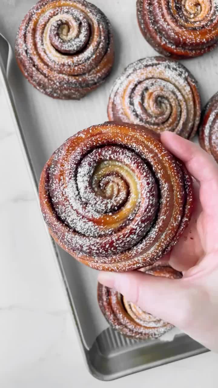 Nutella Brioche Buns ✨  Soft, buttery brioche is swirled with smooth chocolate hazelnut spread, finished with a sweet raspberry simple syrup glaze and a dusting of powdered sugar. The sweetest swirls 🤎  ✨Recipe is on my website and linked in my profile!  https://sweetkitchencravings.com/recipes/nutella-brioche-buns/  #brioche #briochebun #nutella #pastries