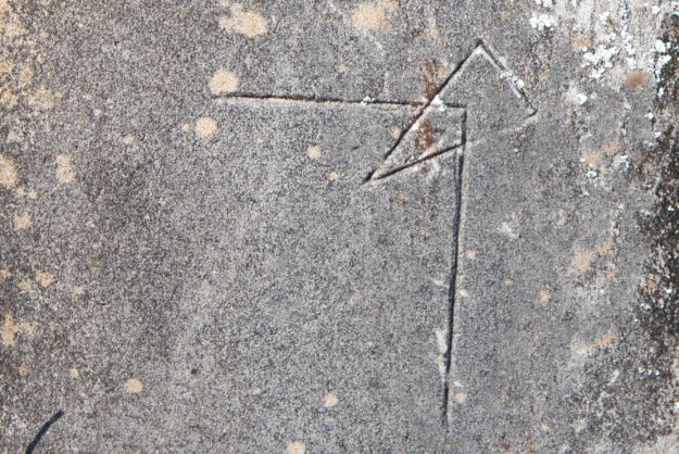An unusual geometric carving on a headstone, featuring a right angle and a triangular point.