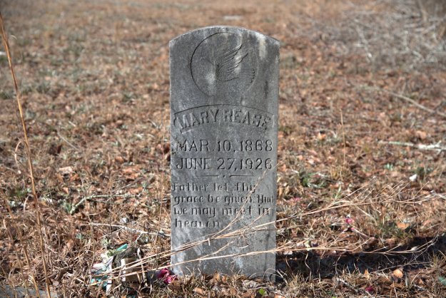A gravestone marking the burial of Mary Rease, with her birth date of March 10, 1868, and death date of June 27, 1926, inscribed along with a message about grace.