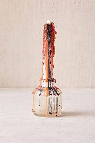 Candle after burning, with rainbow drops dripping down sides