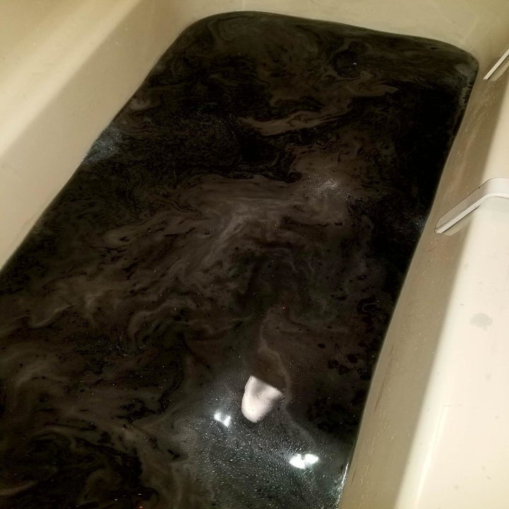 tub filled with iridescent black water