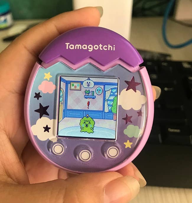a review holding the tamagotchi pix in pink
