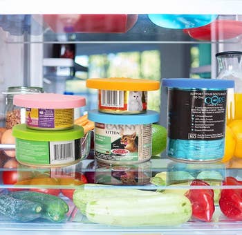 various cans of food in the fridge with silicone lids on them
