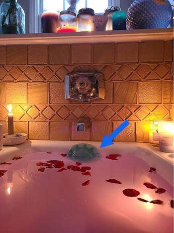 the blue suction cup drain cover installed in a tub with bathwater up to the edges