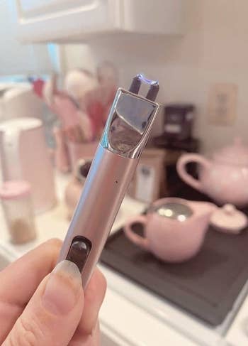 hand holding a pink flameless lighter