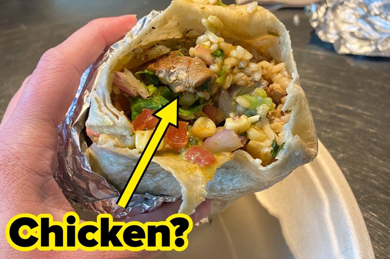 A hand holds a burrito with an arrow pointing to a piece of grilled meat, questioning if it's chicken