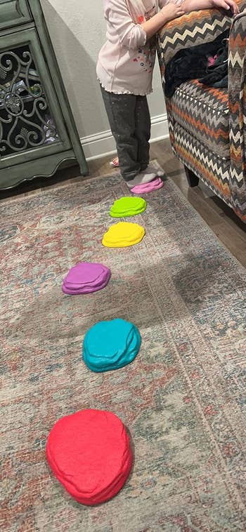 Child stepping on colorful stepping stones in a living room