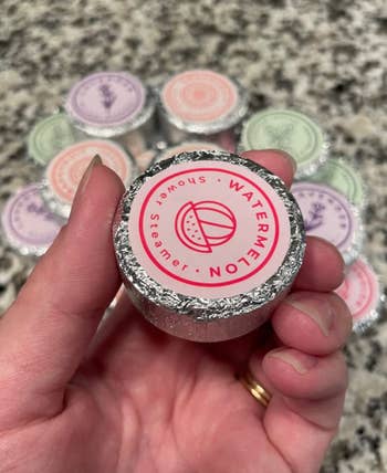 reviewer holding one of the shower steamers in their hand