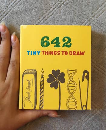 a hand next to the book for scale