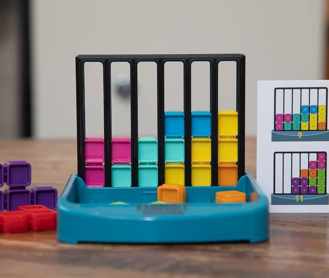the gameboard with slots that fit the colorful block play pieces, and a tray that holds the extra pieces