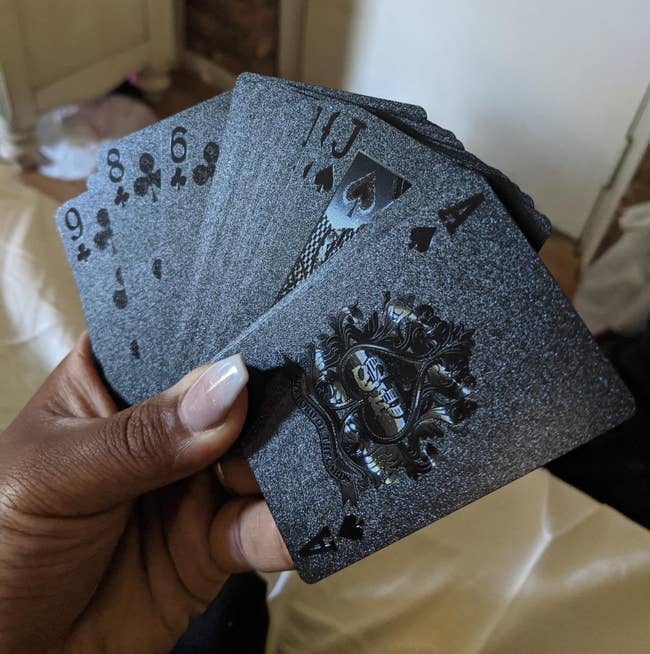 image of reviewer holding the Joyoldelf cards fanned out in their hand