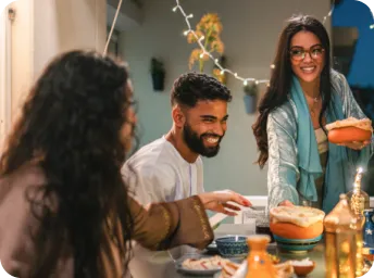 dois amigos rindo enquanto usam um dispositivo móvel para se conectar em uma ligação de vídeo pelo WhatsApp