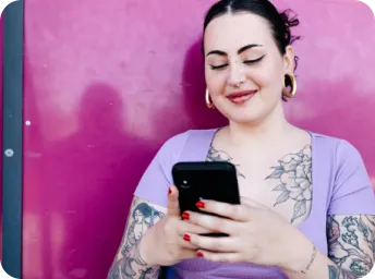 Wanita tertawa menatap perangkat seluler sambil mengobrol di WhatsApp