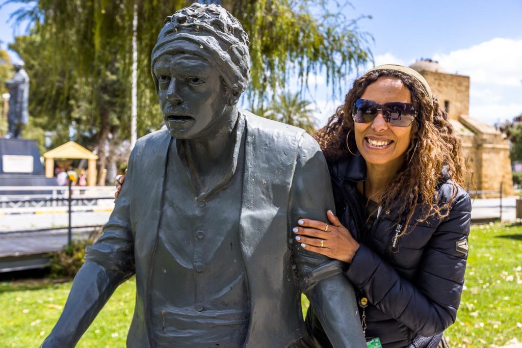 Nelin Tunc an dem Denkmal für ihren Vater Kemal Tunc. Der bekannte Schauspieler und Autor starb 2007. Das Denkmal steht nahe am Kyrina Gate in Nikosia und erinnert an die beliebte Radiosendung und Theaterstücke Alikko und Caher, die das Leben von Türkisch-Zyprioten um 1964 zum Thema haben / © Foto: Georg Berg