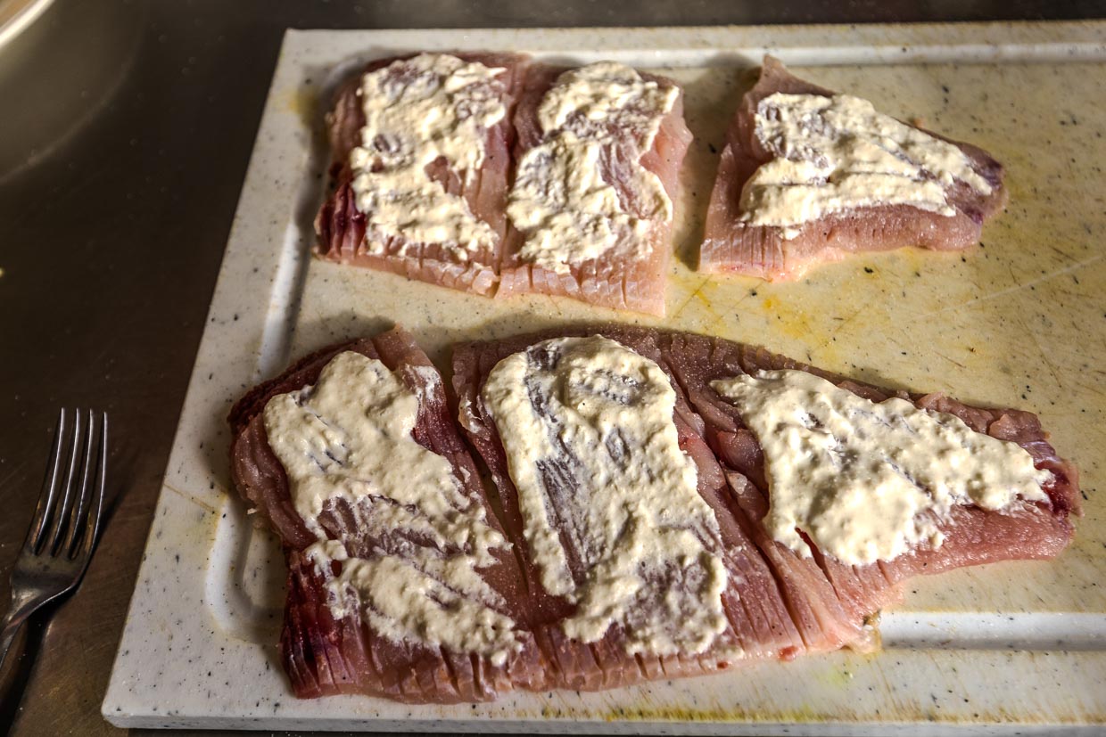 Karpfenfilets mit eingeschnittenen Gräten und bestrichen mit Meerrettichcreme vor dem Braten in der Pfanne. Rezept Fischhof Bächer in Wiesau, Oberpfalz / © Foto: Georg Berg