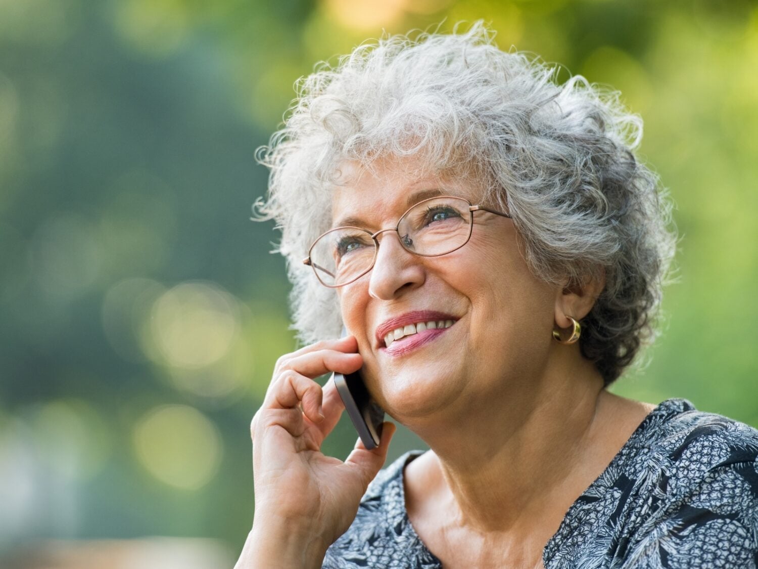 grey haired lady talking on cellphone and smiling