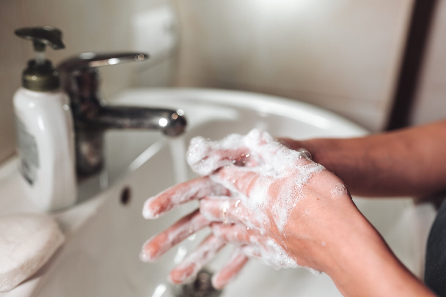 man washing hands with soap and water
