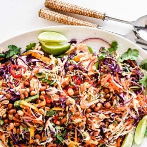 Thai Salad on a platter with serving utensils.