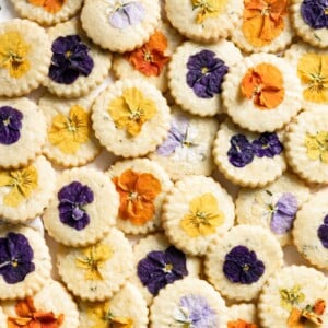 Overlapping shortbread cookies topped with different colored pansies.