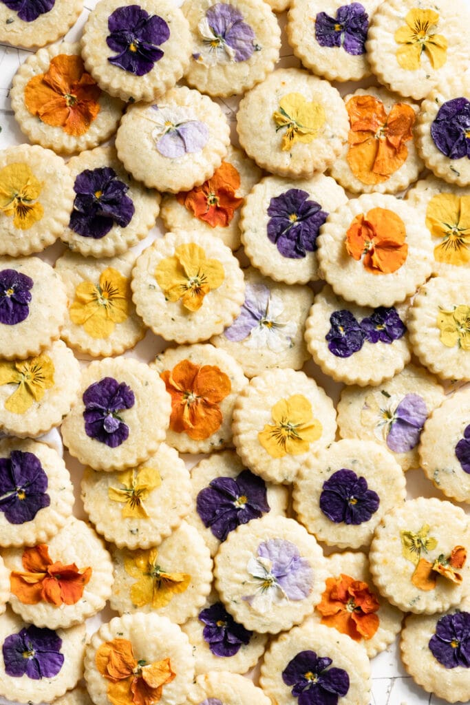 Overlapping shortbread cookies topped with different colored pansies.