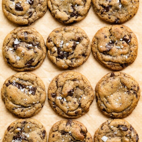Soft baked chocolate chip cookies on a piece of parchment paper.