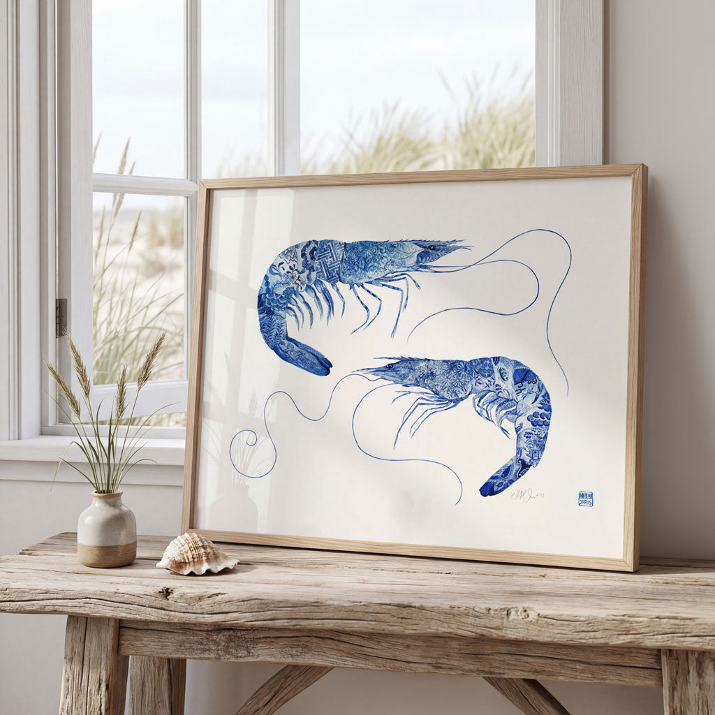 Framed artwork of blue shrimp on a wooden table with a window in the background